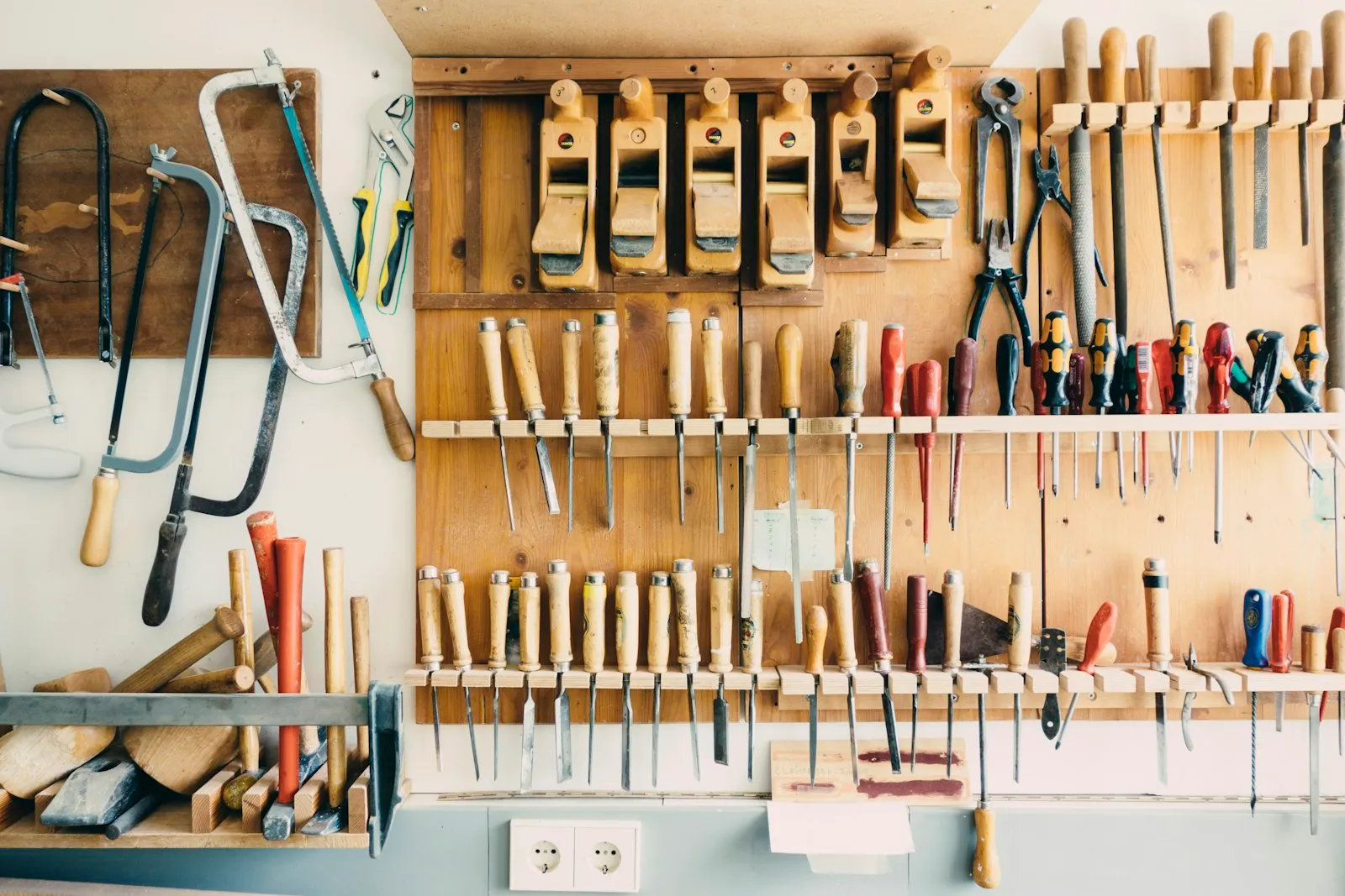 The tool wall at Hartley Joinery β hand planes, chisels and saws on a pegboard