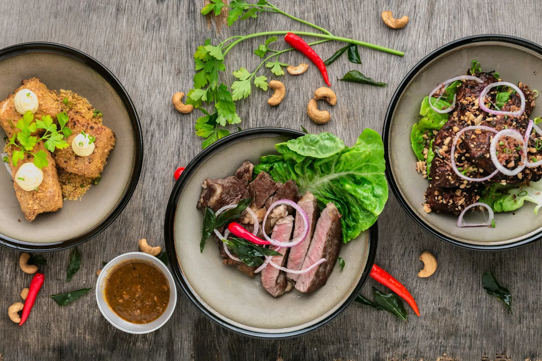 Three sharing plates on a wooden table